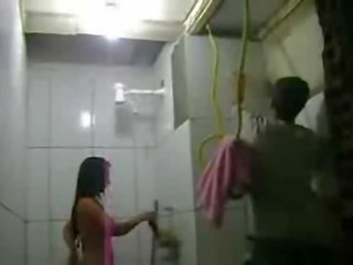 Mulher tomando banho com azulejista nē banheiro