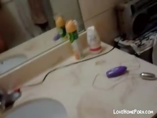 Monada joven asiática masturbándose en la baño